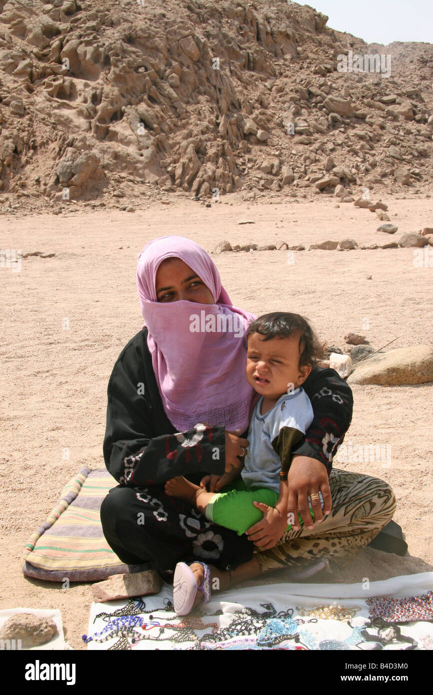 Un Bedowin madre e bambino nel deserto egiziano indossando vestiti tradizionali. Foto Stock