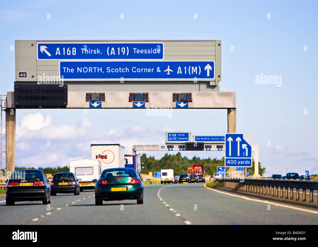 Viaggiando su un'autostrada del Regno Unito, la A1M / A1 con le auto che guidano verso un cartello autostradale in Inghilterra Foto Stock