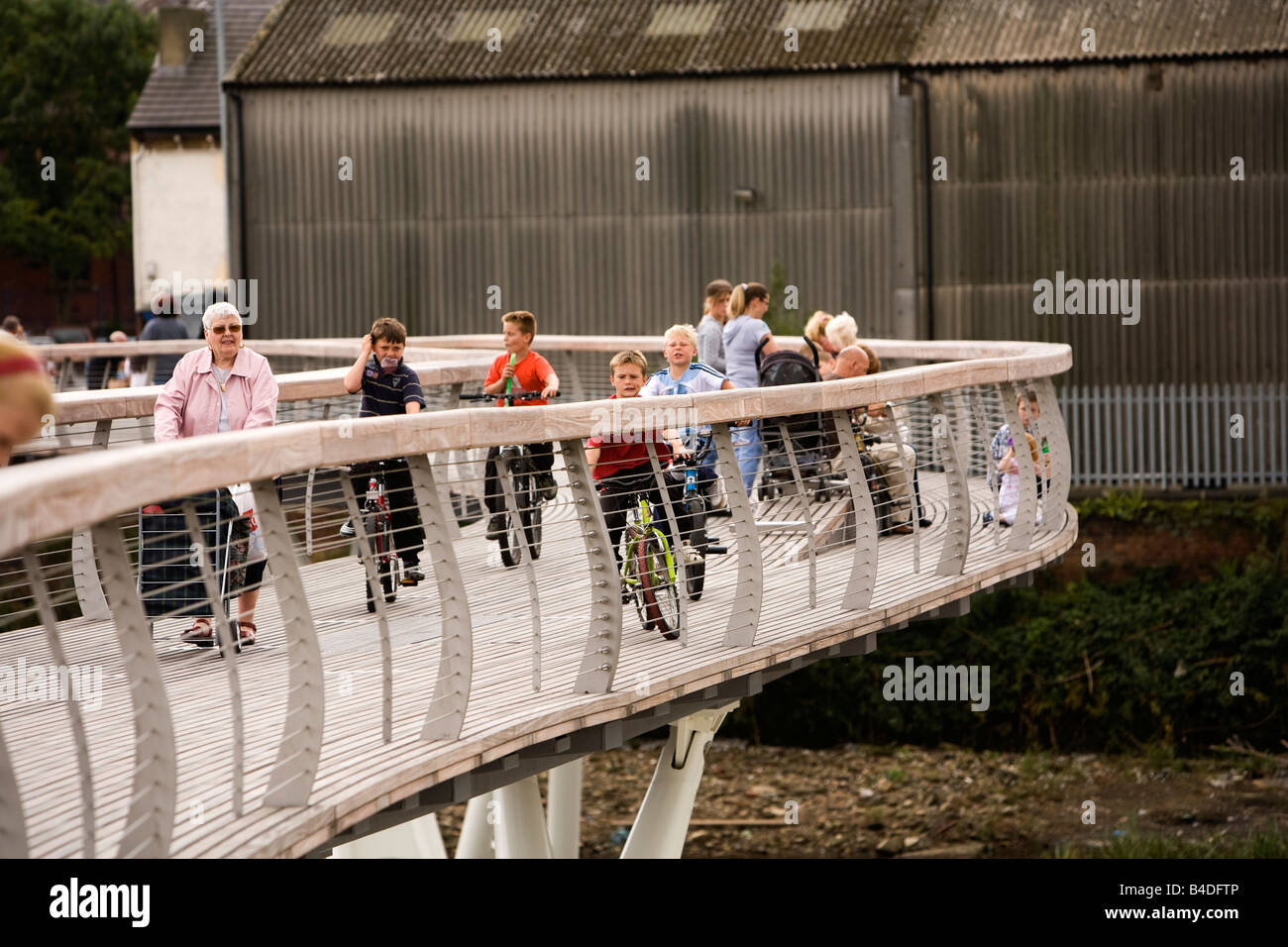 Regno Unito Yorkshire Castleford Grand Designs grande città Piano di bambini in bici attraversando nuova passerella sul fiume Aire Foto Stock