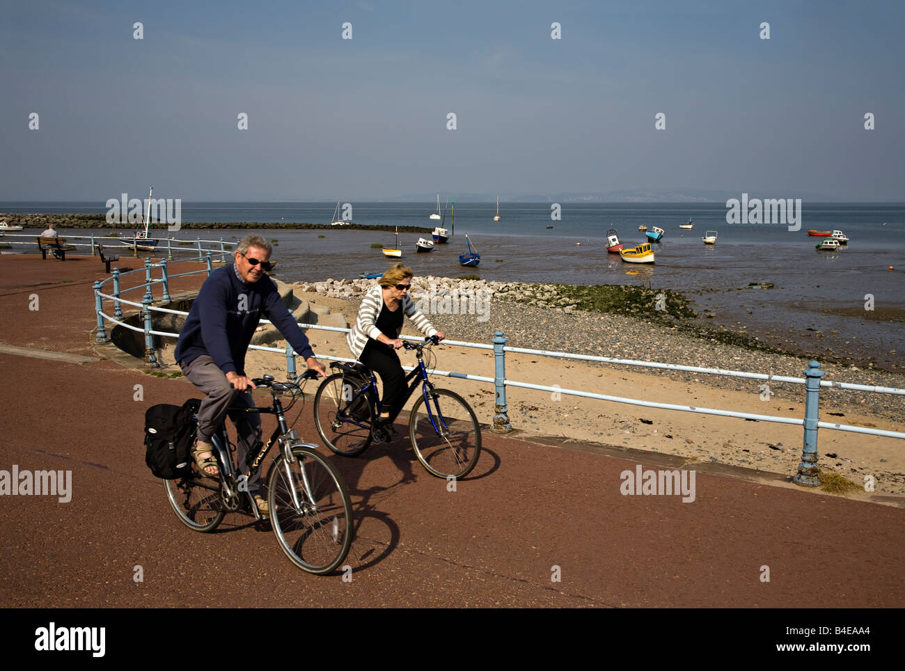 Due persone in bicicletta passeggiate sul lungomare di Morecambe Inghilterra LANCASHIRE REGNO UNITO Foto Stock