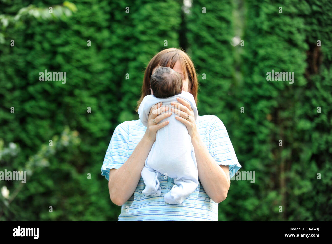 La madre e il neonato giardino amore genitore single cura coltivare l'innocenza dedizione hol proteggere la donna materno infantile Foto Stock