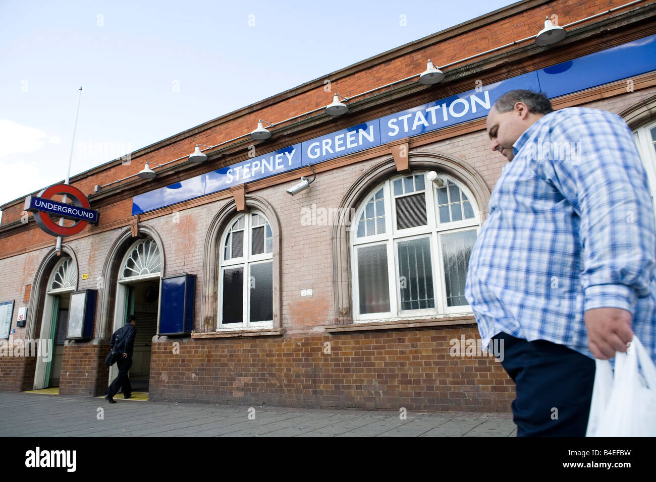 Uomo che cammina da Stepney Green tube station Foto Stock