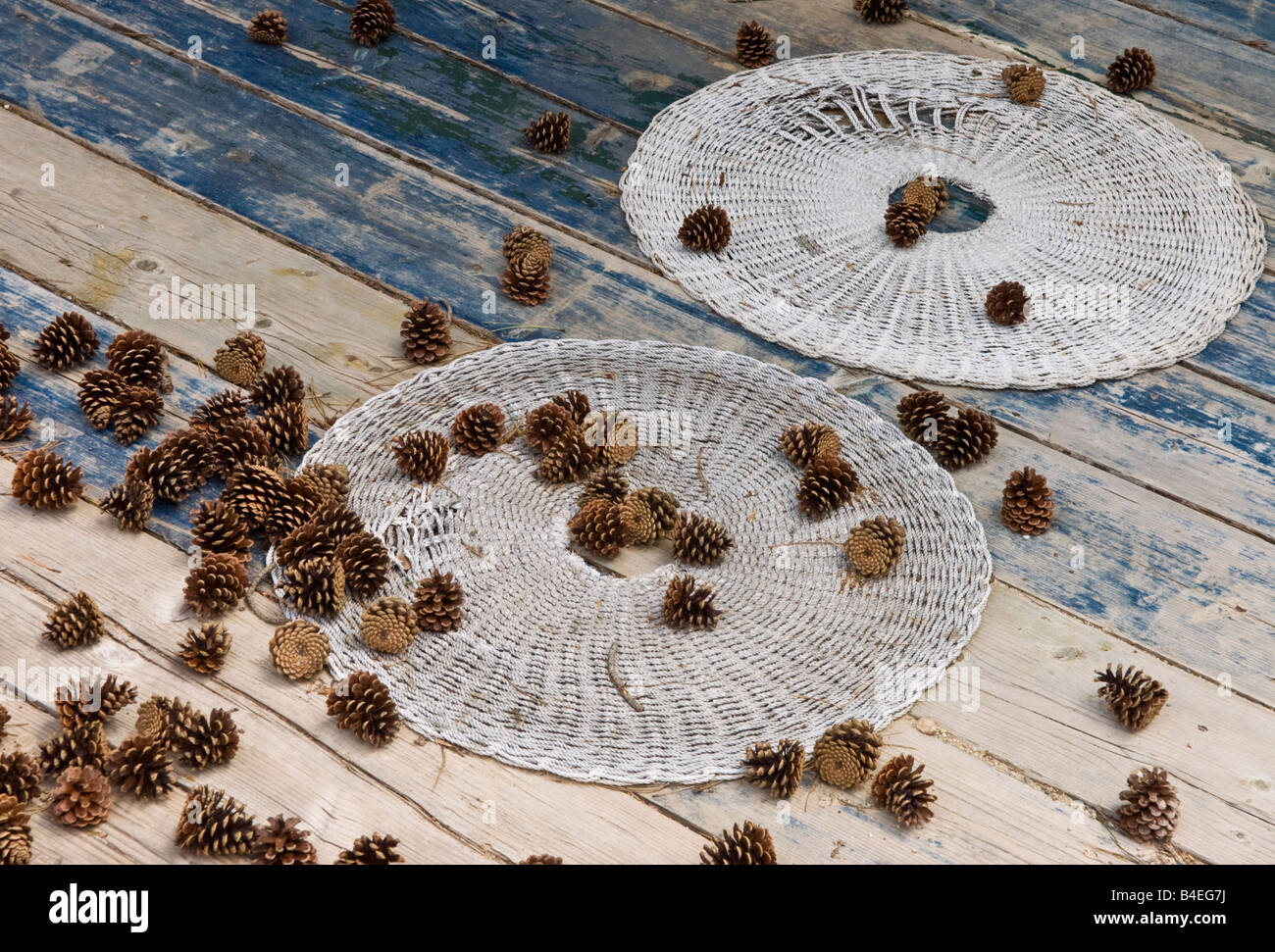 Caduto pigne e vecchio frantoio stuoie sulla veranda in legno piano di una baita di montagna di Mani esterna sud del Peloponneso Grecia Foto Stock