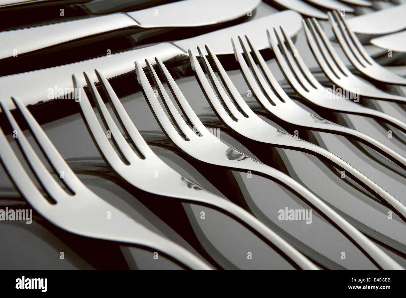 Acciaio inox silver set di posate su un laureato sfondo nero con la riflessione compresi coltello Cucchiaio e forchetta Foto Stock