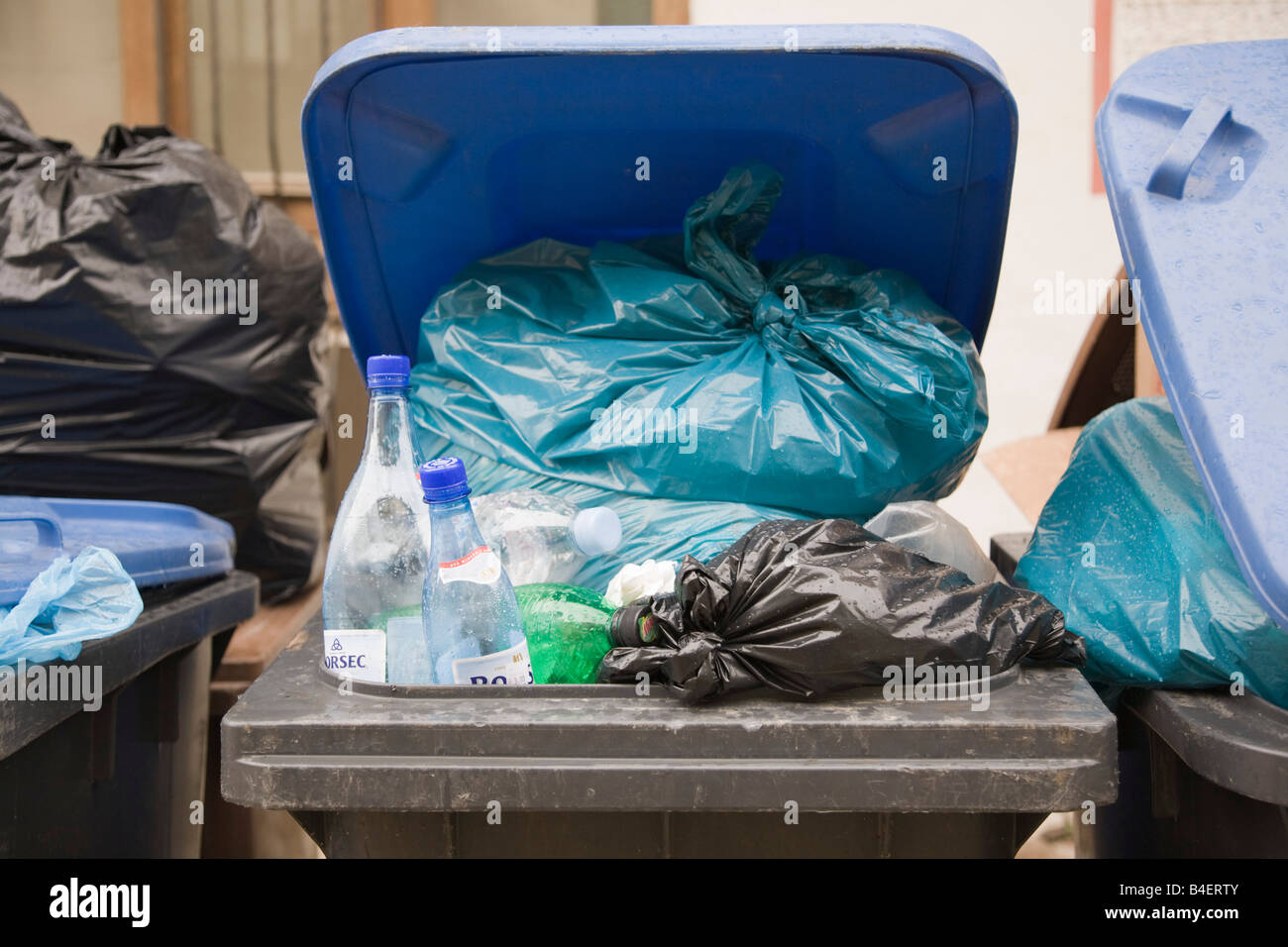 La Romania Europa bidone con ruote con coperchio aperto rifornito in eccesso con sacchetti di plastica Foto Stock