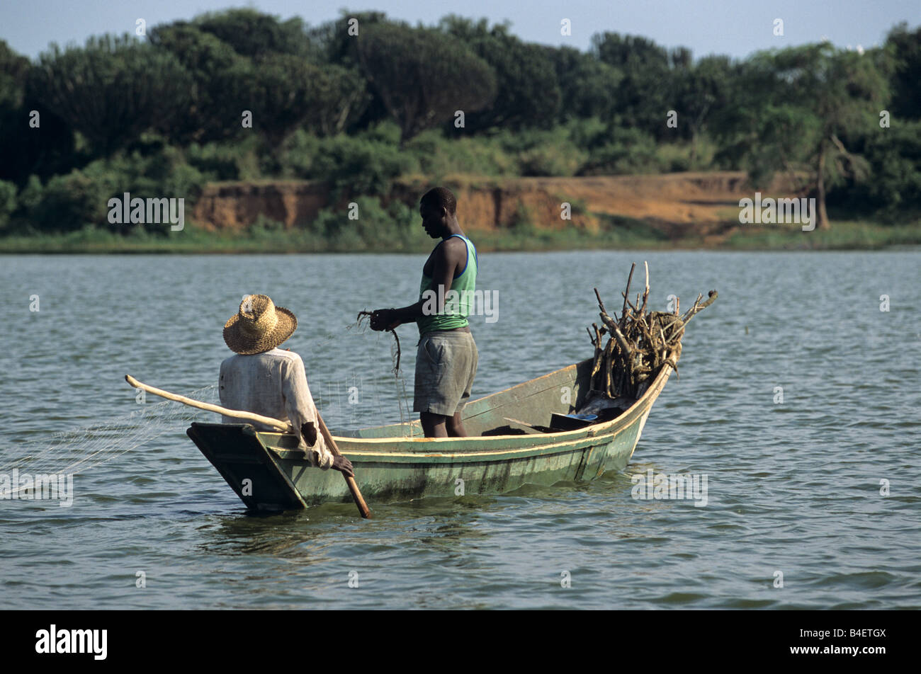 I pescatori locali al netto di colata da barca a galla lago calmo. Uganda. Foto Stock