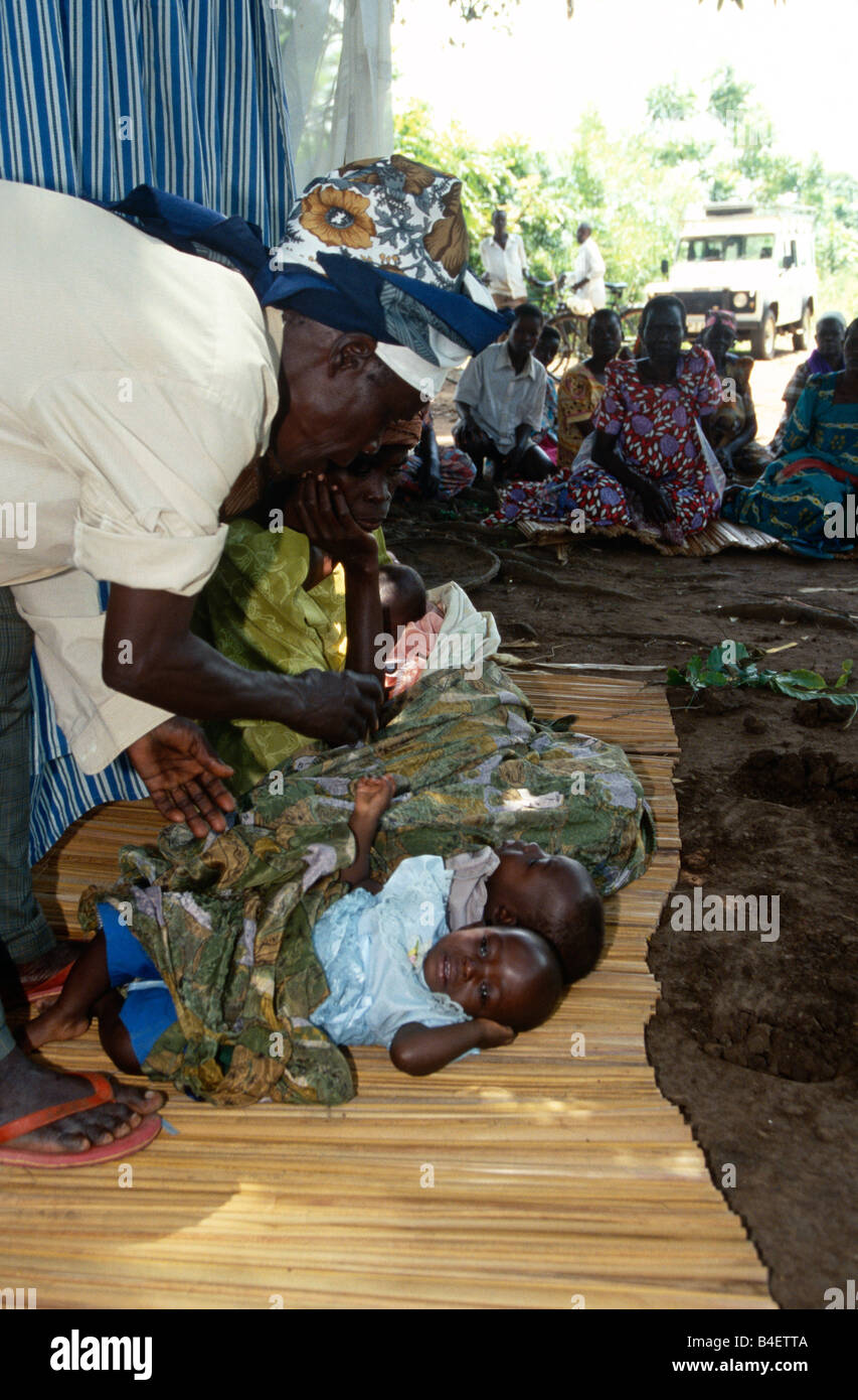Gli abitanti di un villaggio in attesa di vedere stregone, Uganda Foto Stock