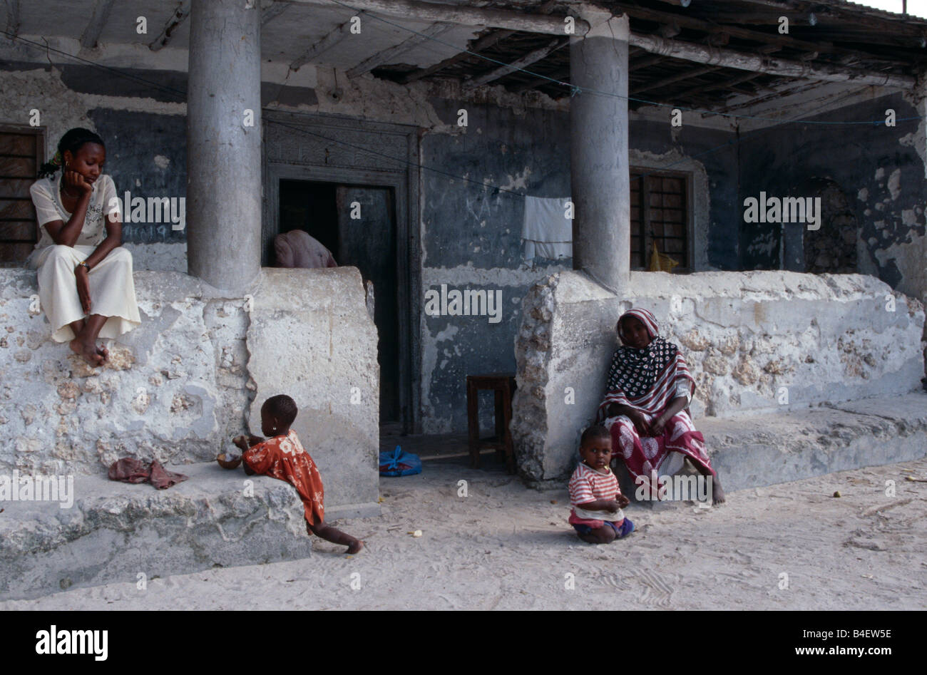 Donne locali e i loro figli di fronte a casa. Zanzibar. Foto Stock