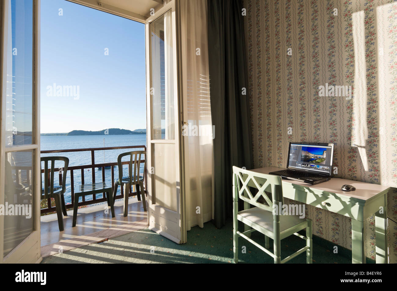 Il computer portatile su una scrivania in un hotel fronte lago e camera, Belgirate, Lago Maggiore, Italia Foto Stock