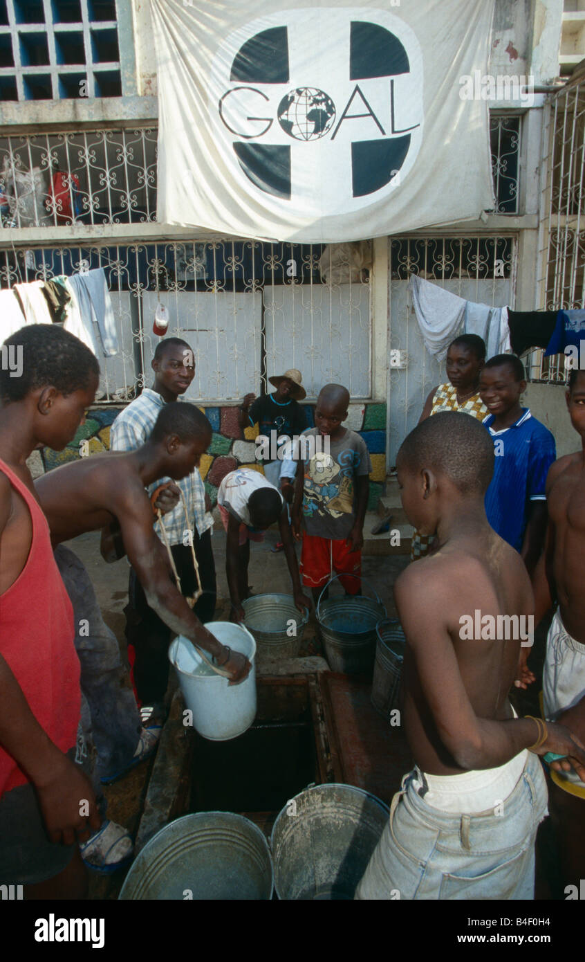 Ragazzi la raccolta di acqua a scopo di ONG acqua sito aiuto, Angola Foto Stock