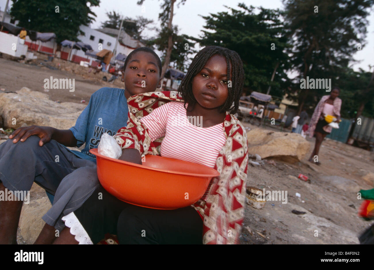 I bambini in attesa con vasca sul settore dei rifiuti, Angola Foto Stock