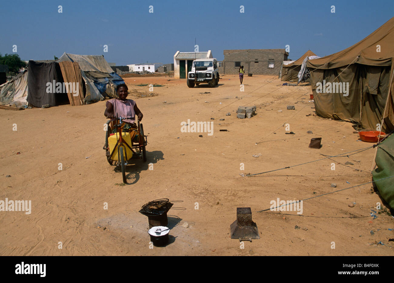 La donna che porta sul triciclo a sfollati camp, Angola Foto Stock