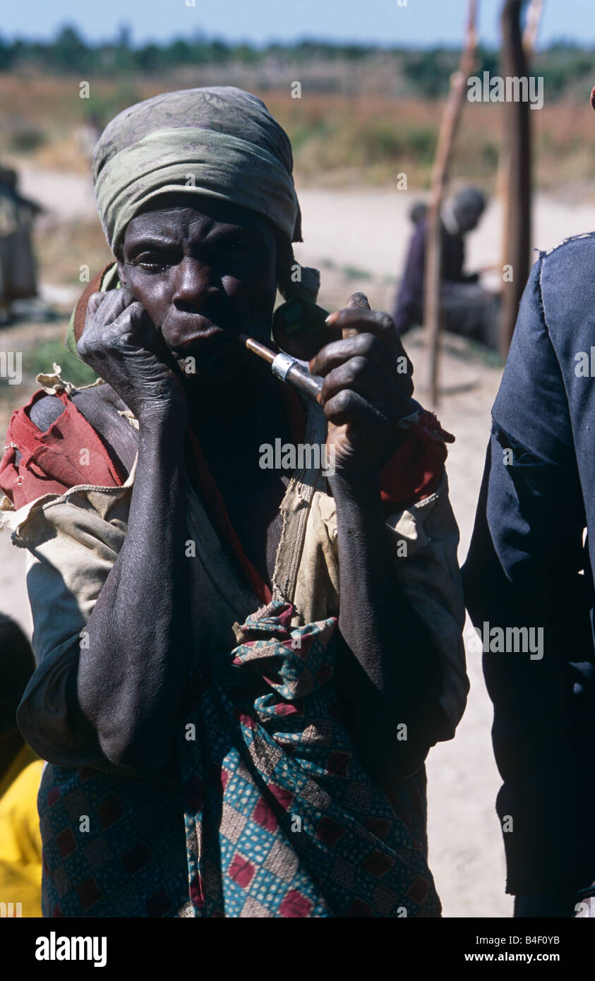 Senior donna accigliata e tubo di fumo in sfollati camp, Angola Foto Stock