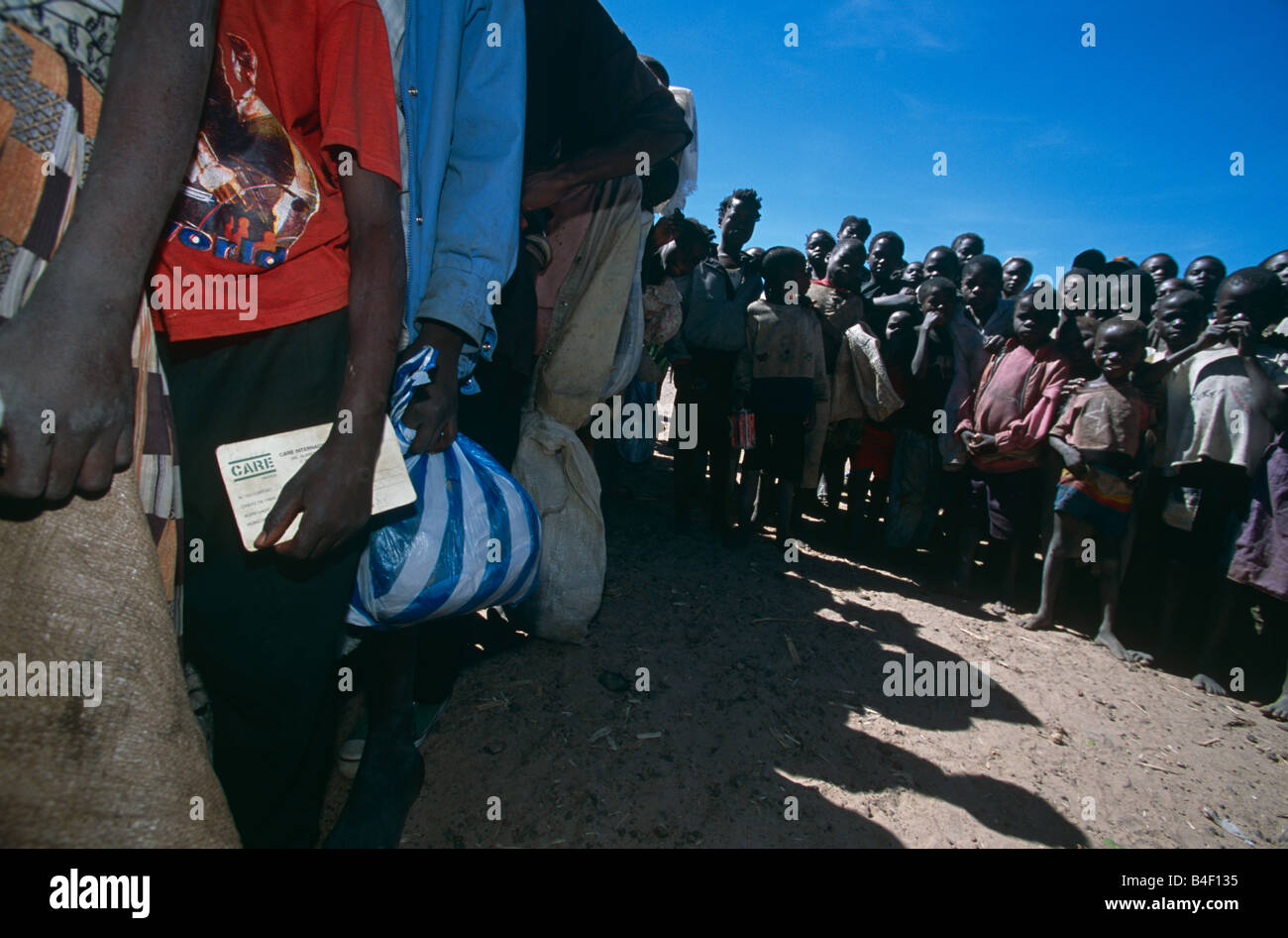 Gli sfollati coda per ricevere la distribuzione degli aiuti da ONG a cura di un accampamento in Angola. Foto Stock