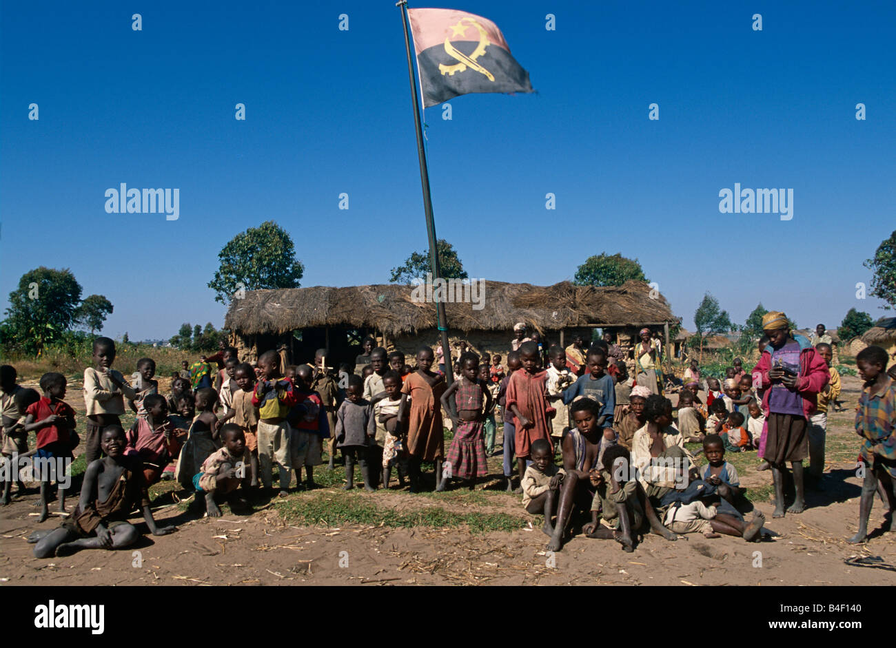 I bambini al di sotto di permanente nazionale angolana bandiera a sfollati camp, Angola Foto Stock