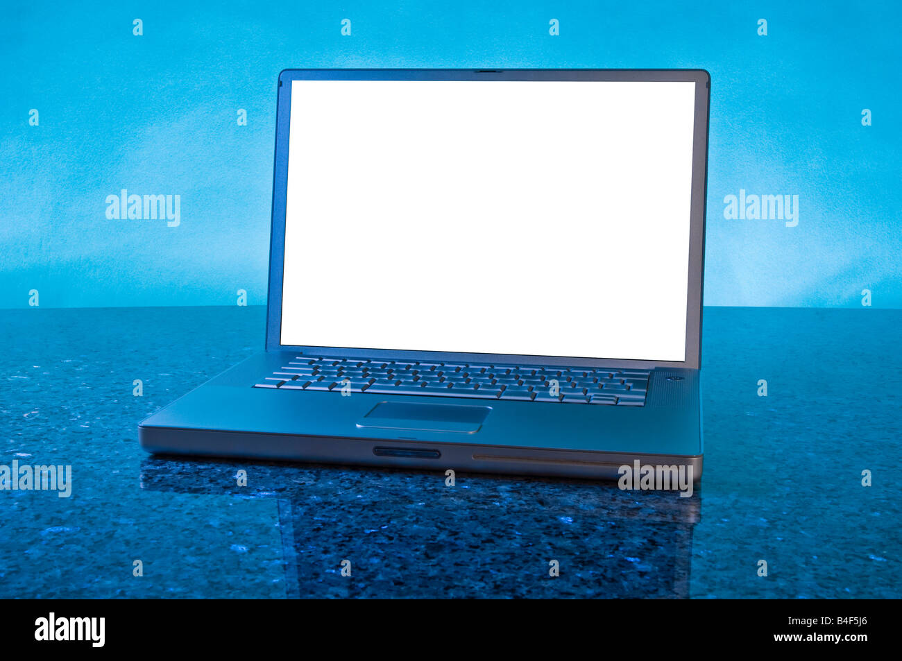 Giro laptop PC su piastra in marmo sfondo blu titolo foto spazio per il layout del testo silver screen computing monitor MAC Powerbook Foto Stock