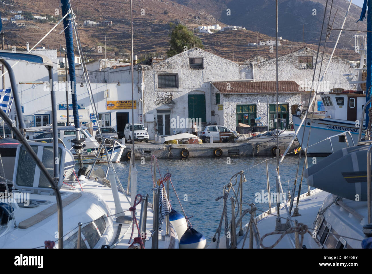 Porto tra due barche con il vecchio magazzino bianco edificio a Città di Paros isola di Paros Cicladi Mar Egeo Grecia Foto Stock