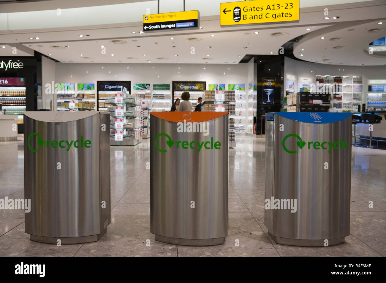 La Gran Bretagna REGNO UNITO tre codificato a colori in acciaio inox cassonetti per il riciclaggio all'interno di Heathrow Airport terminal Foto Stock