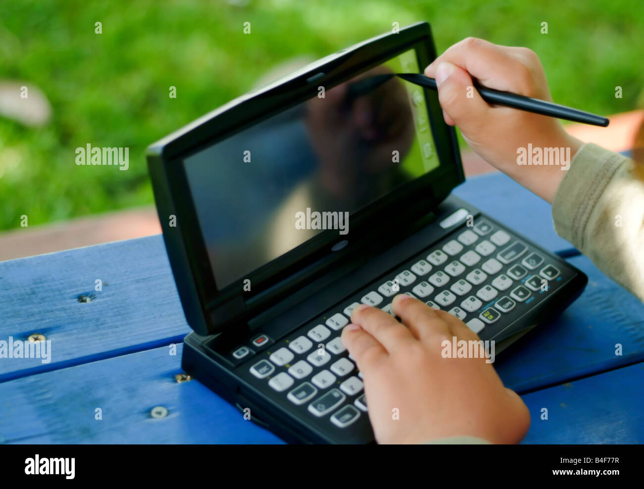 Bambino scrivendo una digitazione su un PDA Foto Stock