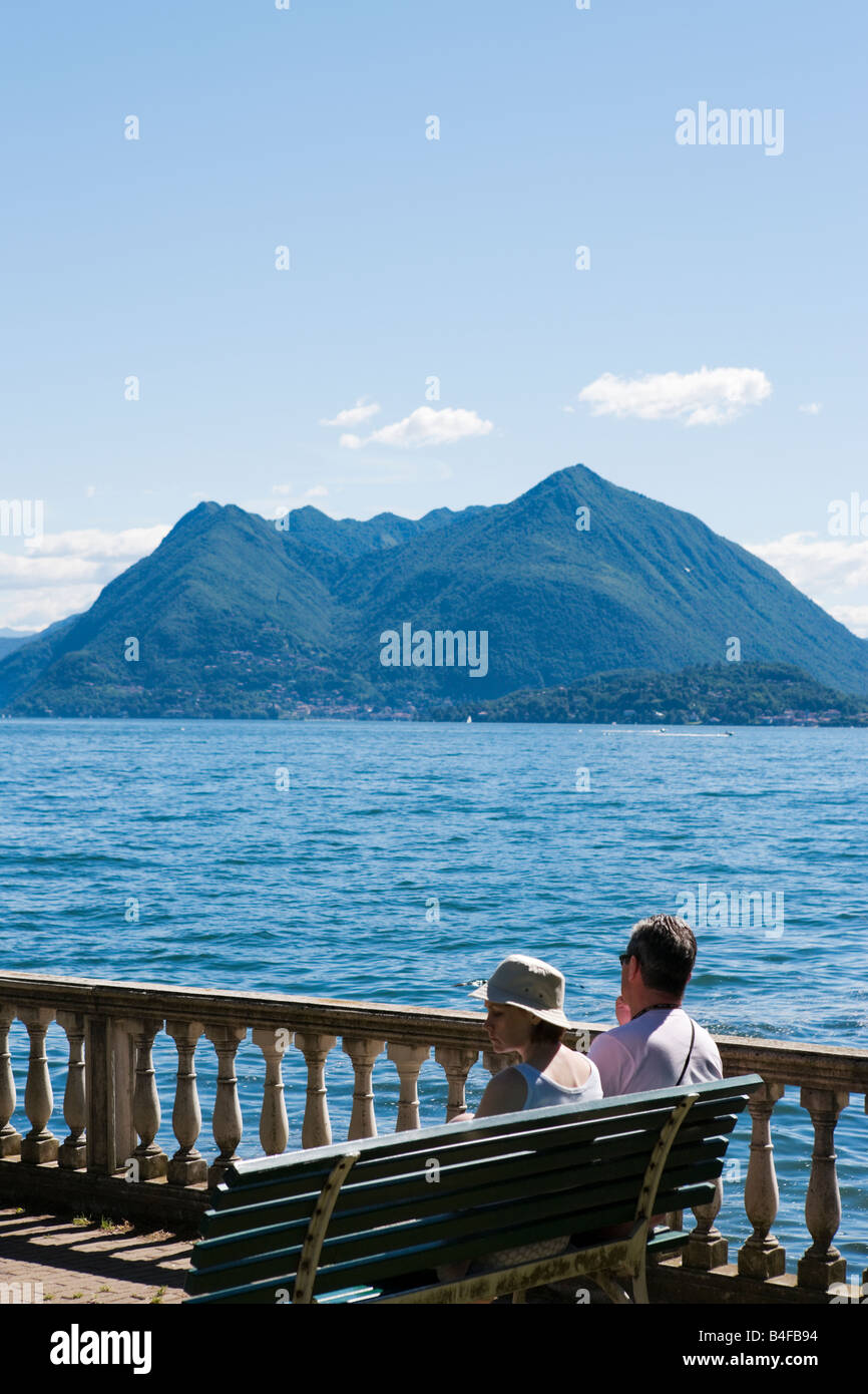 Coppia seduta su una panchina sul lago, Stresa, Lago Maggiore, Italia Foto Stock