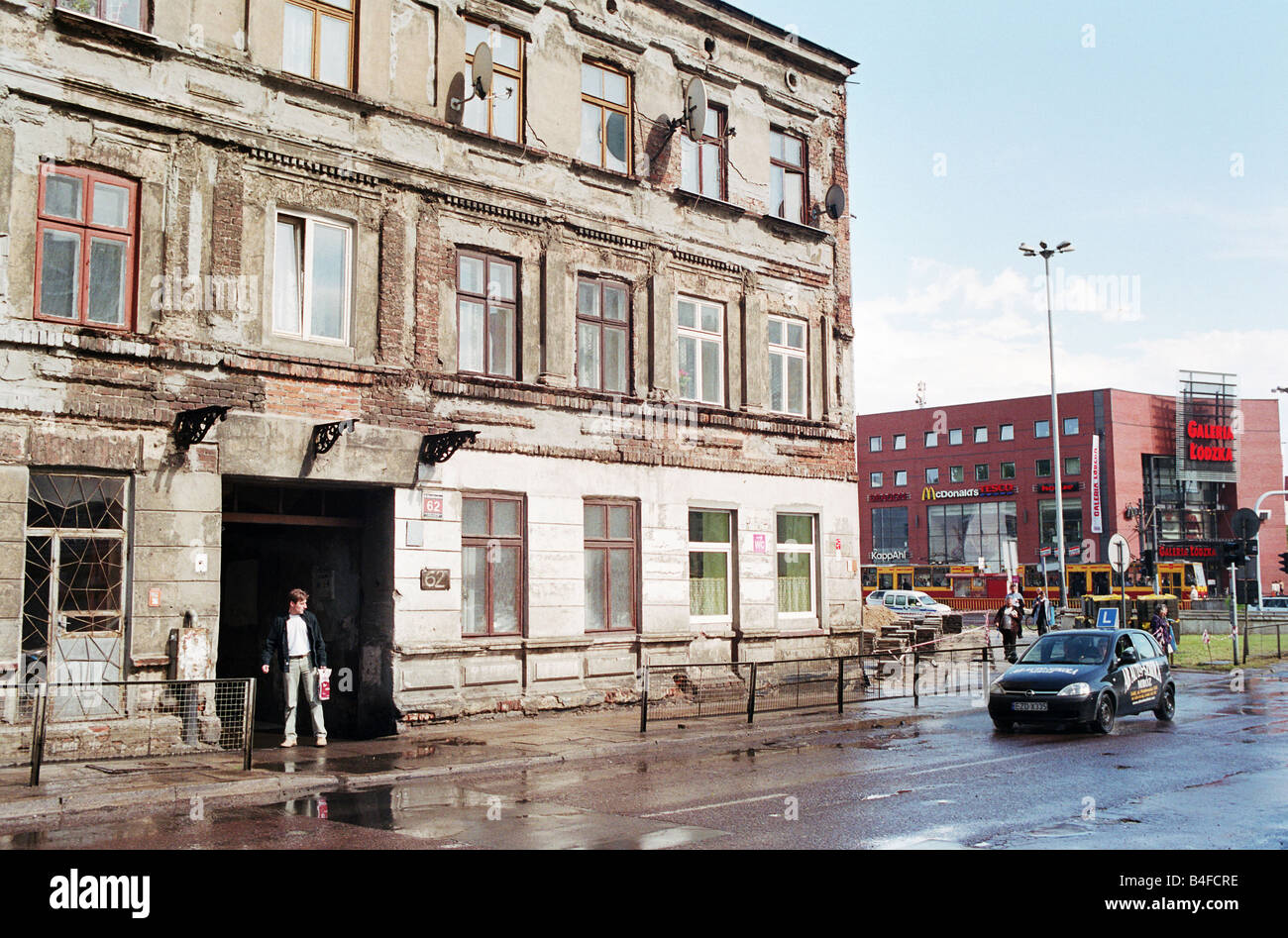 Il vecchio malandato edificio, con un centro commerciale in backgorund, a Lodz, Polonia Foto Stock