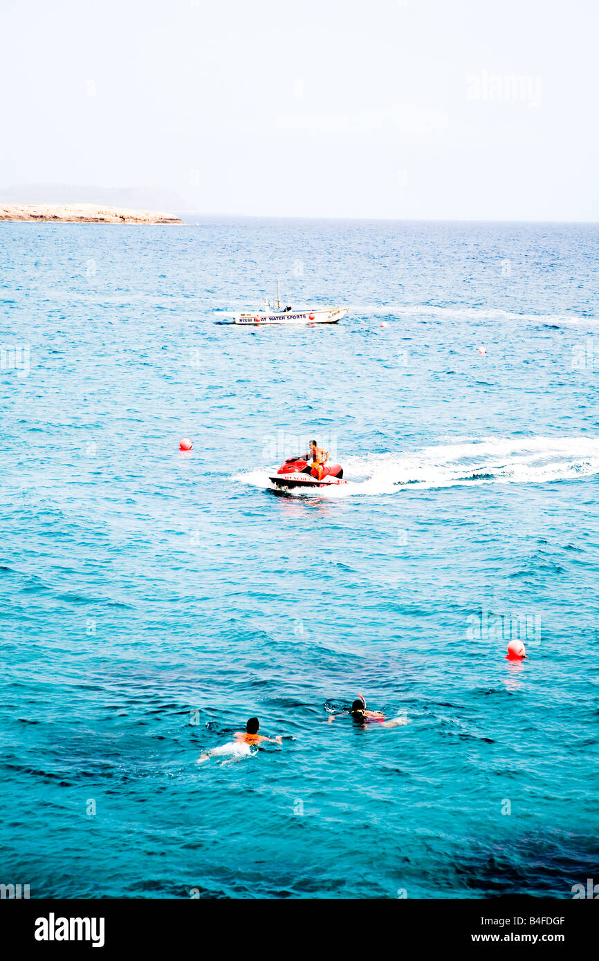 Salvataggio di un jet ski pattugliano le acque al largo di Nissi beach, Cipro, con i nuotatori in acqua Foto Stock