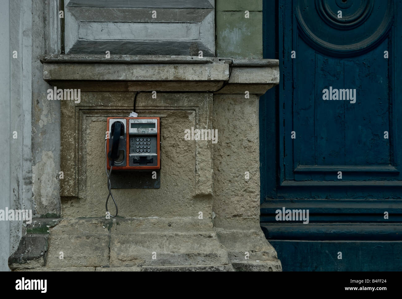Telefono pubblico a una strada nel centro di Cluj Napoca, Romania Transilvania regione, accanto a una porta blu Foto Stock