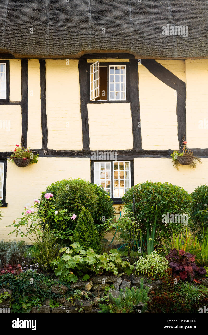 Close-up di un con il tetto di paglia, telaio di legno dipinto di bianco, tipico paese inglese cottage a tutti Cannings, Wiltshire, Inghilterra, Regno Unito Foto Stock