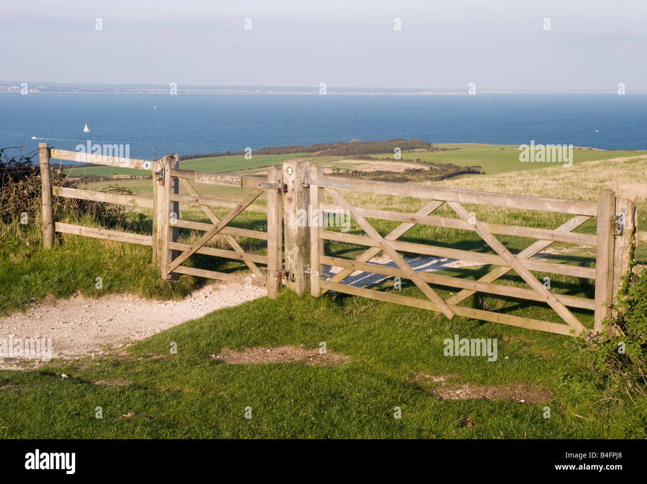 Cancello in legno sulla collina tra Studland e Swanage affacciato sulla Baia di Poole, con Bournemouth in distanza Foto Stock