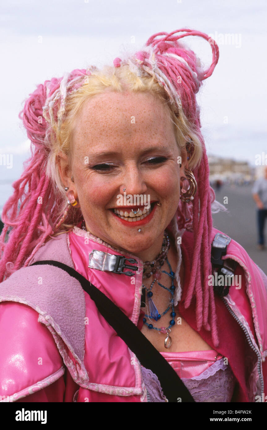 Close-up di giovane donna con la faccia piercing e rosa dreadlocks Foto Stock