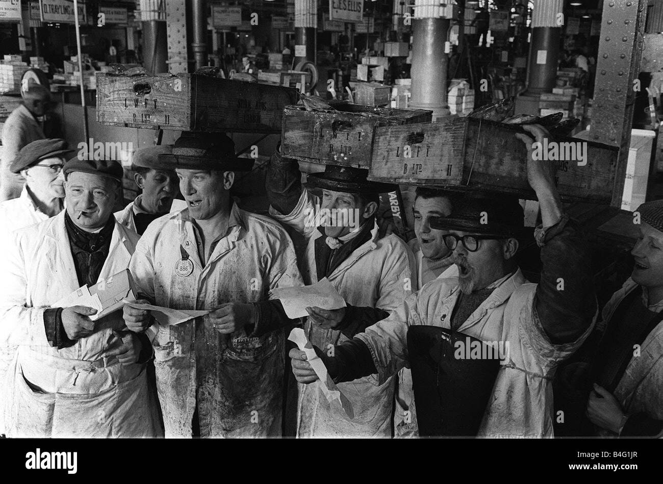 I portinai presso Billingsgate a Londra ha preso una pausa dal pesce di traino per cantare un canto natalizio service 1962 Foto Stock