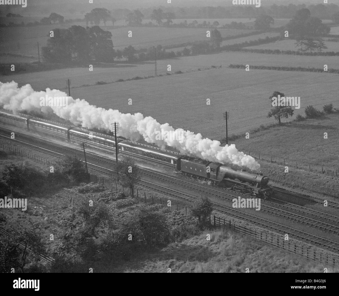 Pacifico LNER locomotiva a vapore a piena velocità lasciando una scia di fumo come le gare attraverso la campagna di Hertfordshire Foto Stock