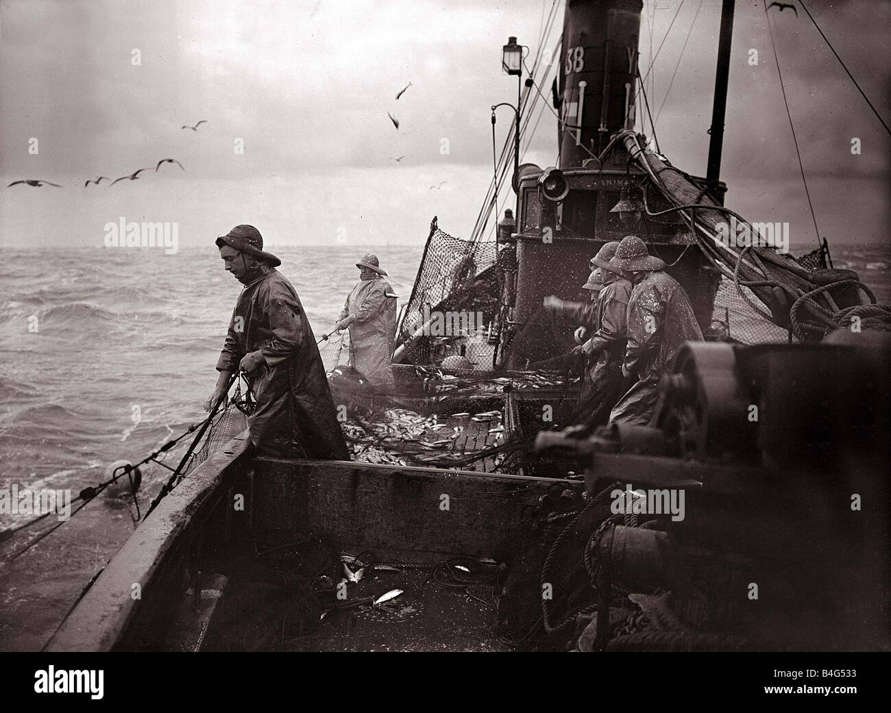 L'equipaggio di un Yarmouth Aringa barca tirare le proprie catture su una tempesta scagliata nel mare del Nord circa 1935 Foto Stock