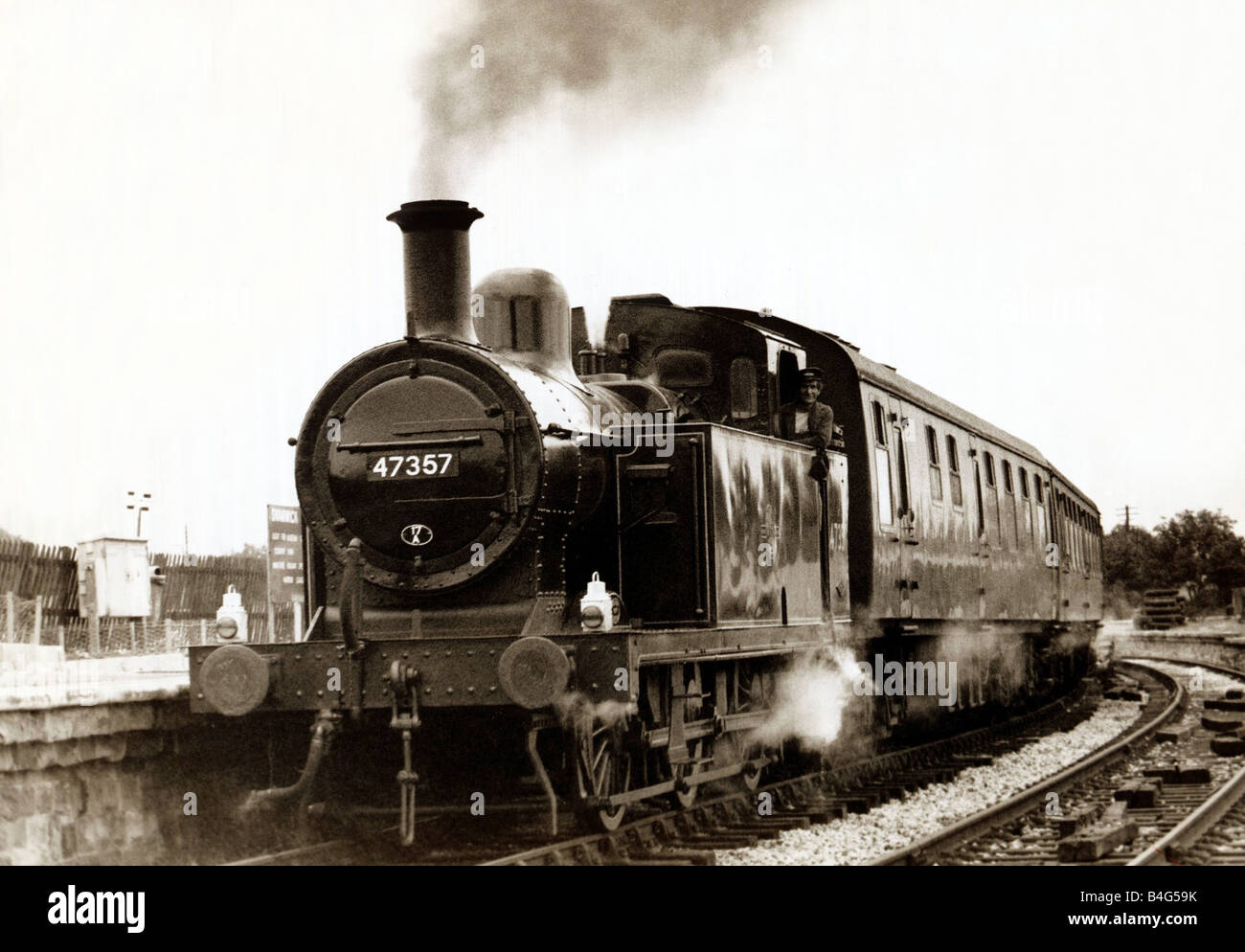 Un serbatoio del motore arriva in corrispondenza di una zona rurale Inglese stazione ferroviaria su una linea di conservazione circa 1990 Foto Stock