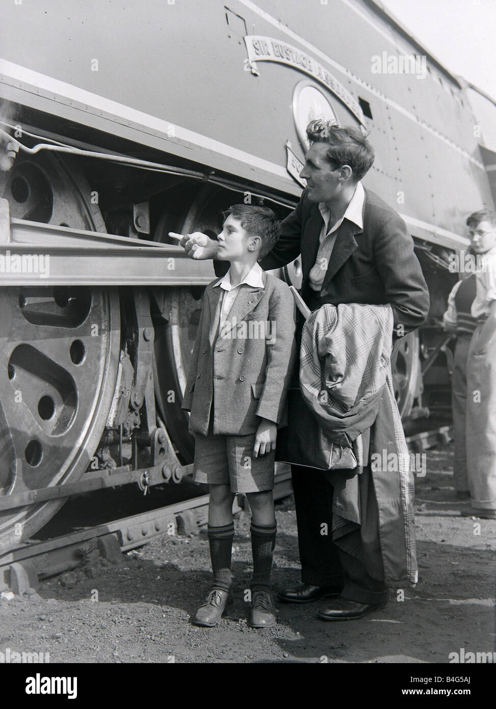 Un padre e figlio ammirare la locomotiva a vapore durante una giornata aperta a Ashford opere ferroviarie Agosto 1949 Foto Stock