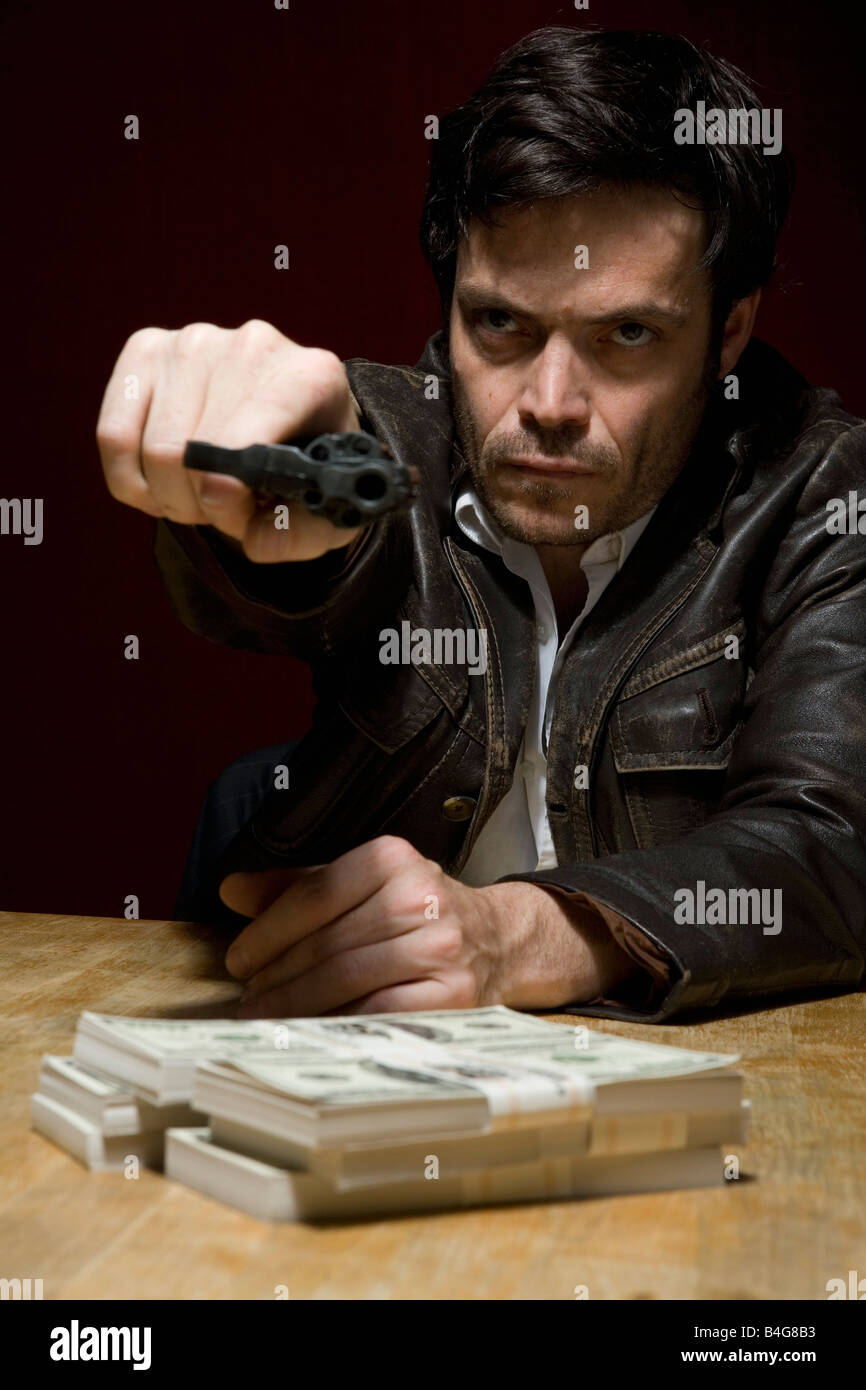 Un uomo in possesso di una pistola minacciosamente Foto Stock