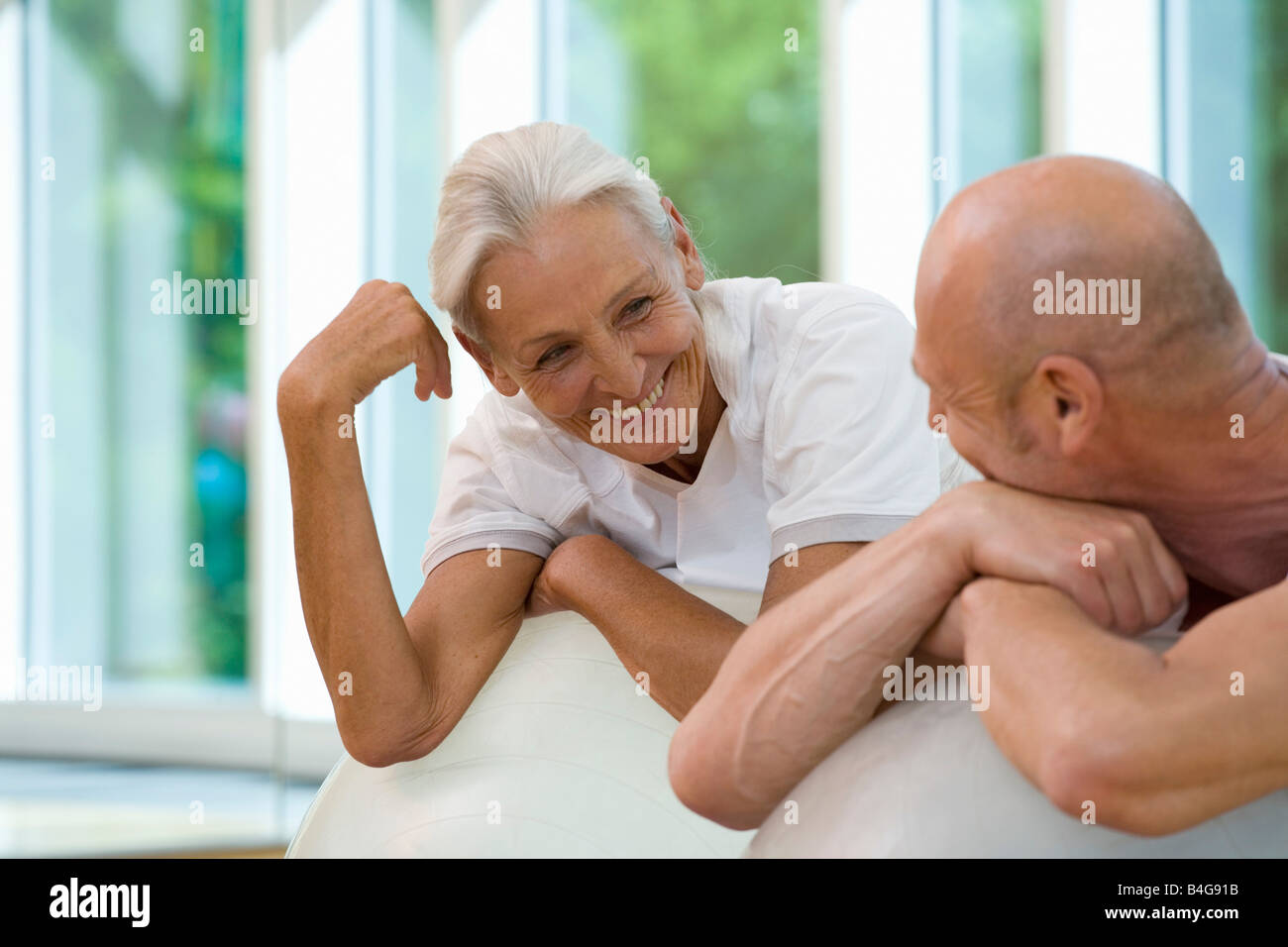 Un uomo maturo e una donna senior poggiando su palle ginniche Foto Stock