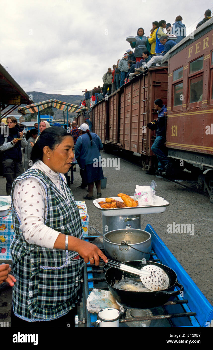 I turisti e la gente del posto a bordo della Devils naso convoglio ferroviario sedersi sulla parte superiore dei vagoni ferroviari che ha fermato a Alausi per cibo. Foto Stock