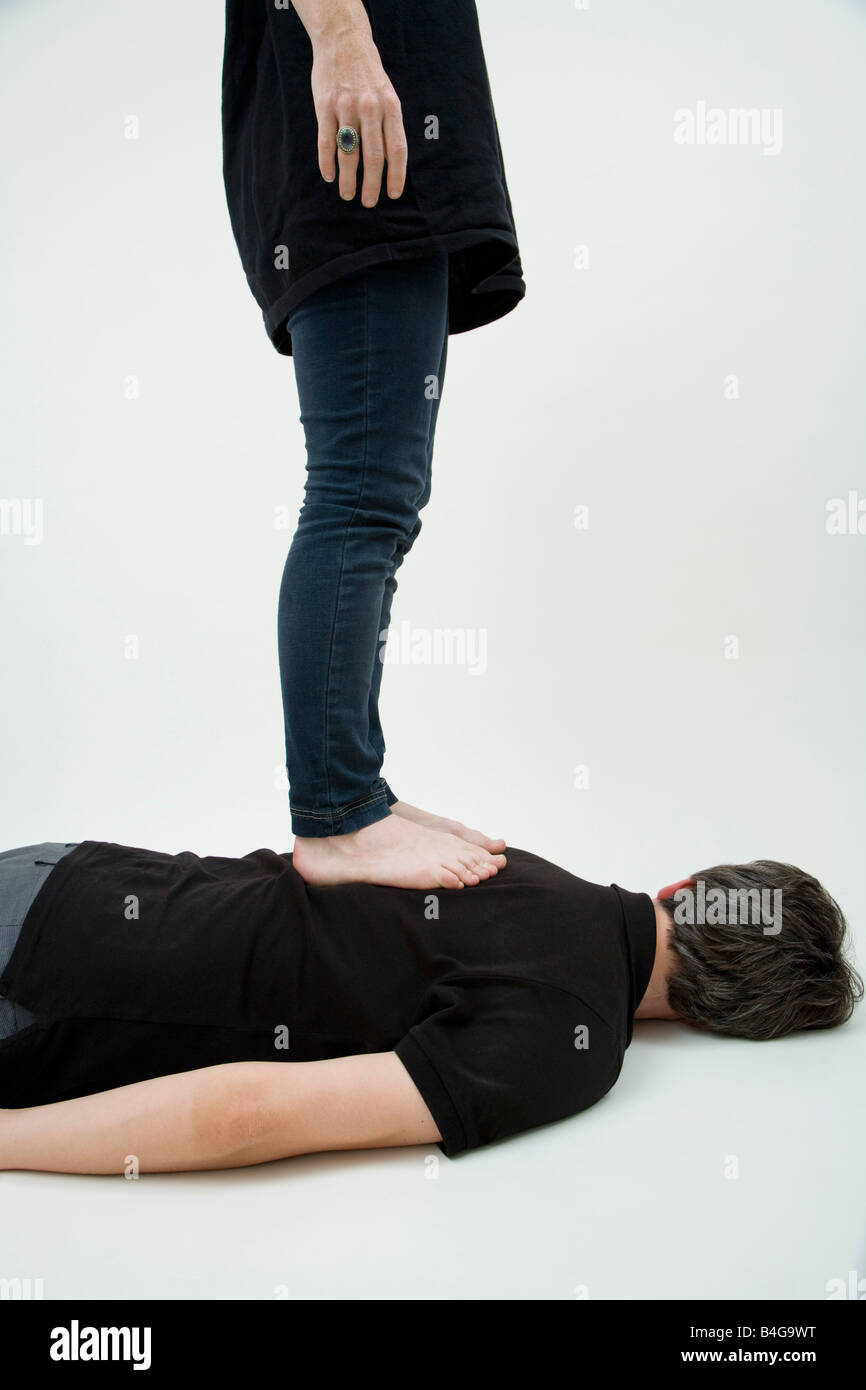 Una donna in piedi su un uomo con la schiena, oscurato volti Foto Stock