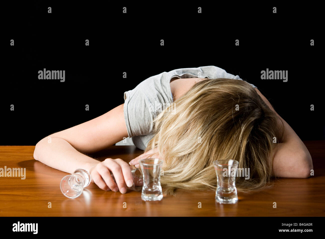 Una giovane donna ha passato fuori ubriaco su un banco di bar Foto Stock