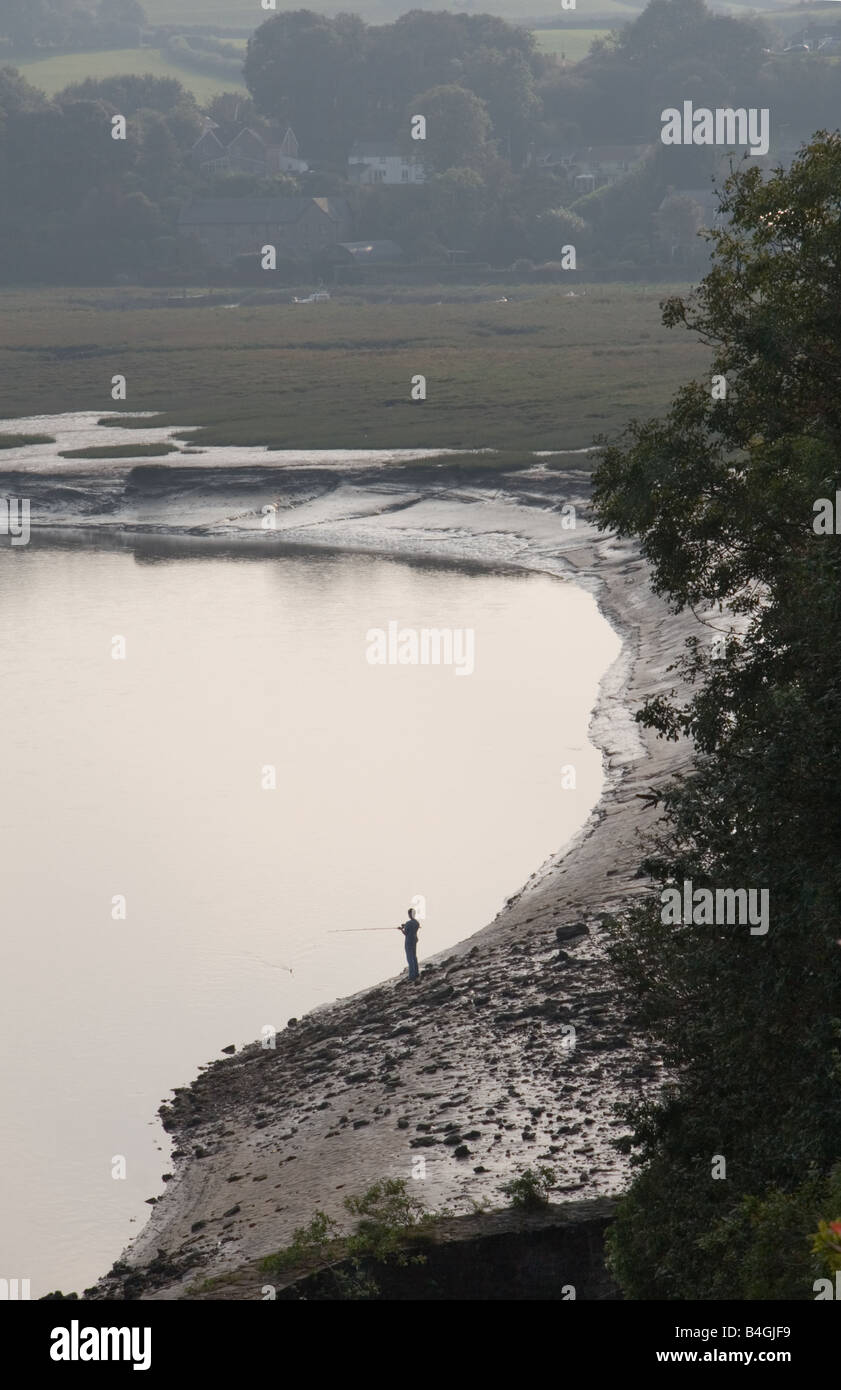 Un pescatore solitario sul fiume Taff mudbanks, Laugharne, Carmarthen, Wales, Regno Unito Foto Stock