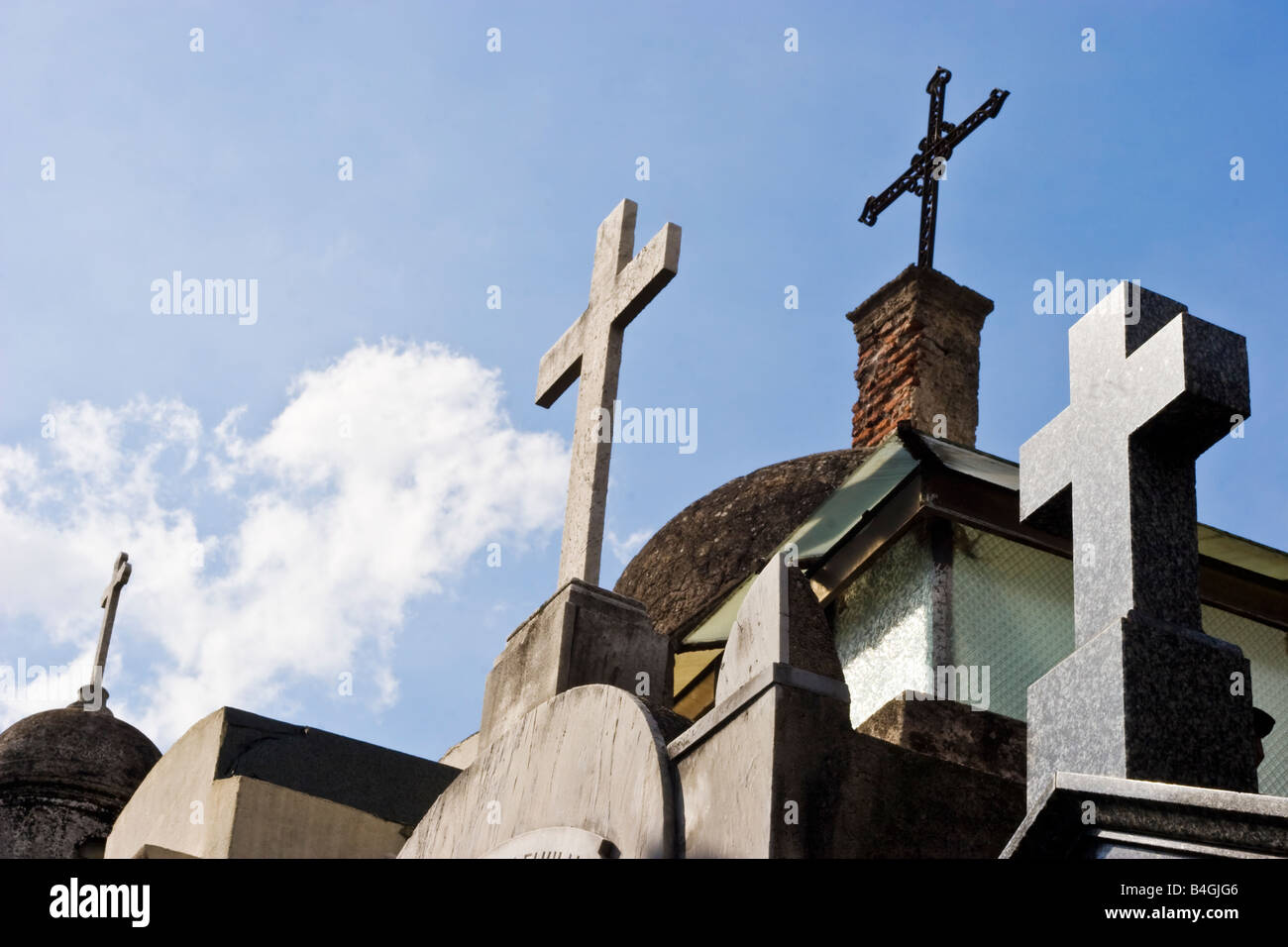 Crocifissi sulla parte superiore di una fila di tombe nel cimitero di Recoleta Foto Stock