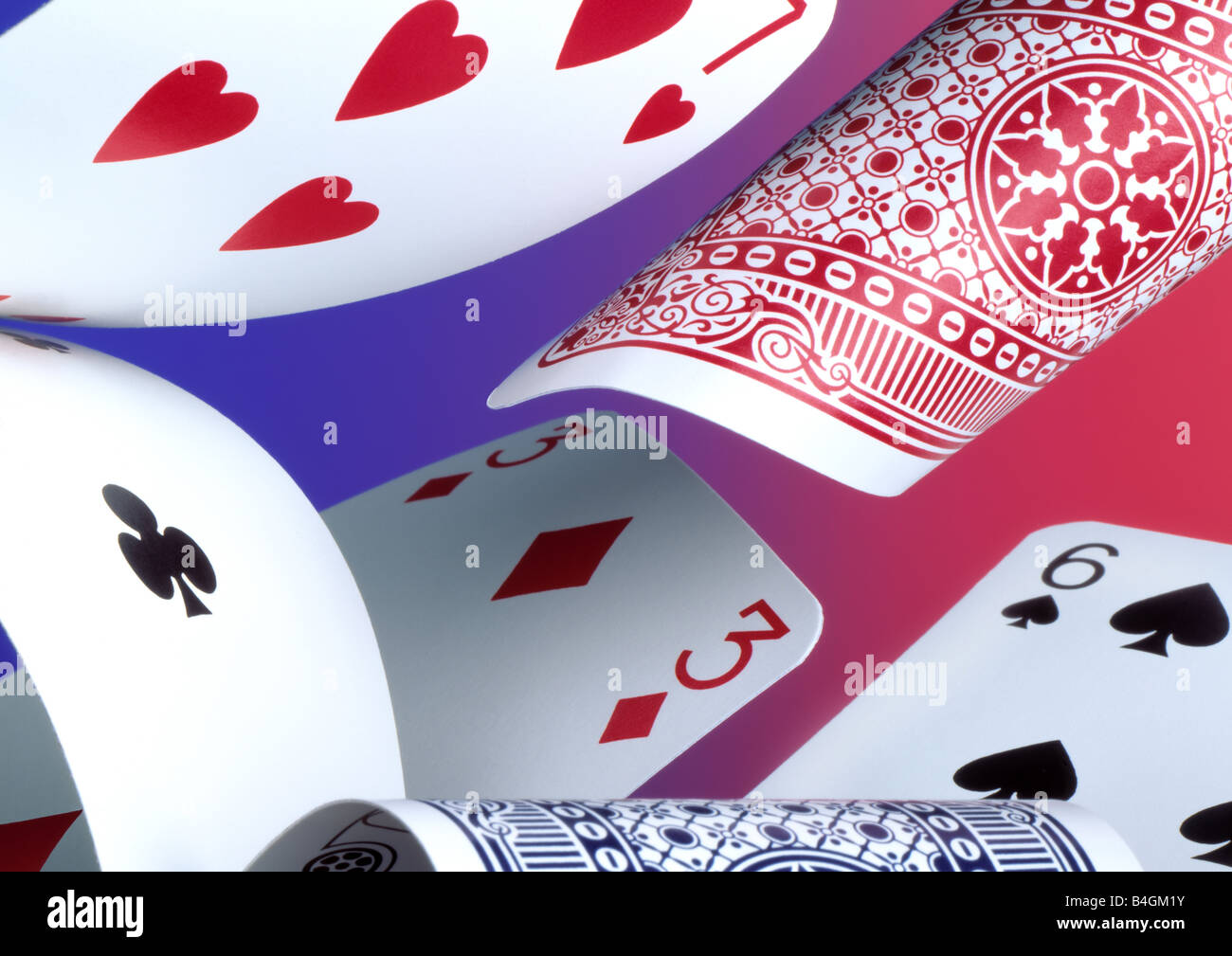 La caduta di carte da gioco su un blu e sfondo rosso Foto Stock