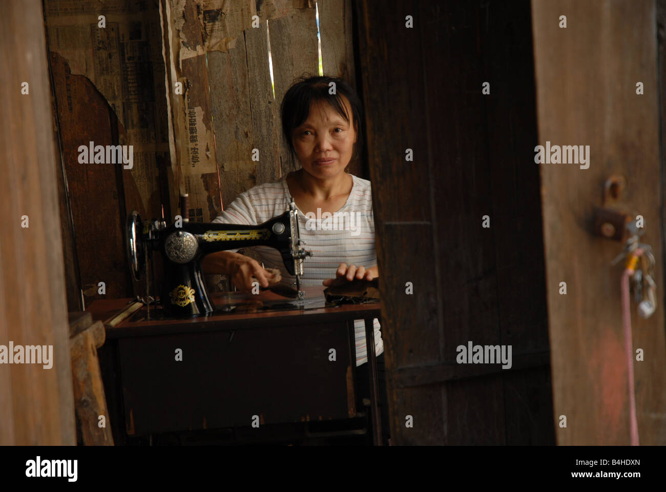Una donna con la sua macchina da cucire in zone rurali Municipalità di Chongqing, Cina. Foto Stock