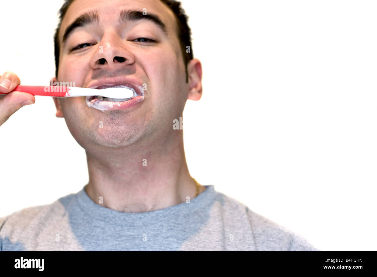 Un primo piano di un giovane uomo mentre egli sta spazzolando i suoi denti Foto Stock