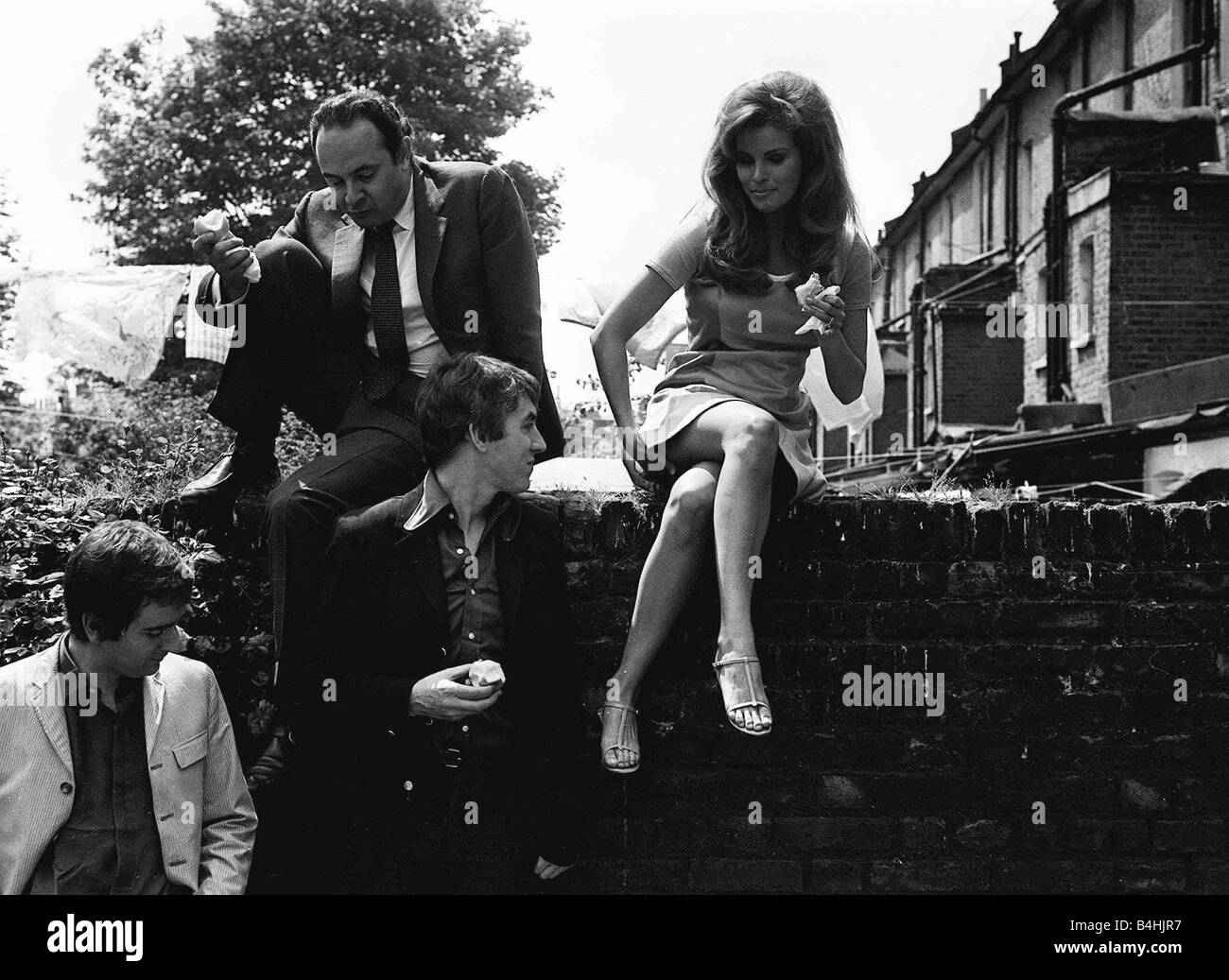 Film Bedazzled 1967 Raquel Welch con Peter Cook e Dudley Moore Peter Cook ottiene una buona vista fino Raquel Welch s gonna come si prendono una pausa dalle riprese per un pasto veloce Foto Stock