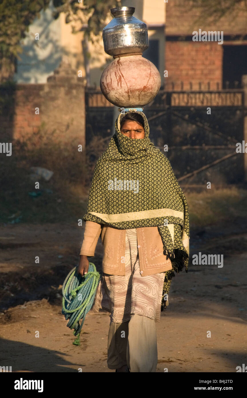Donna indiana che trasportano l'acqua sul suo capo il modo tradizionale Foto Stock
