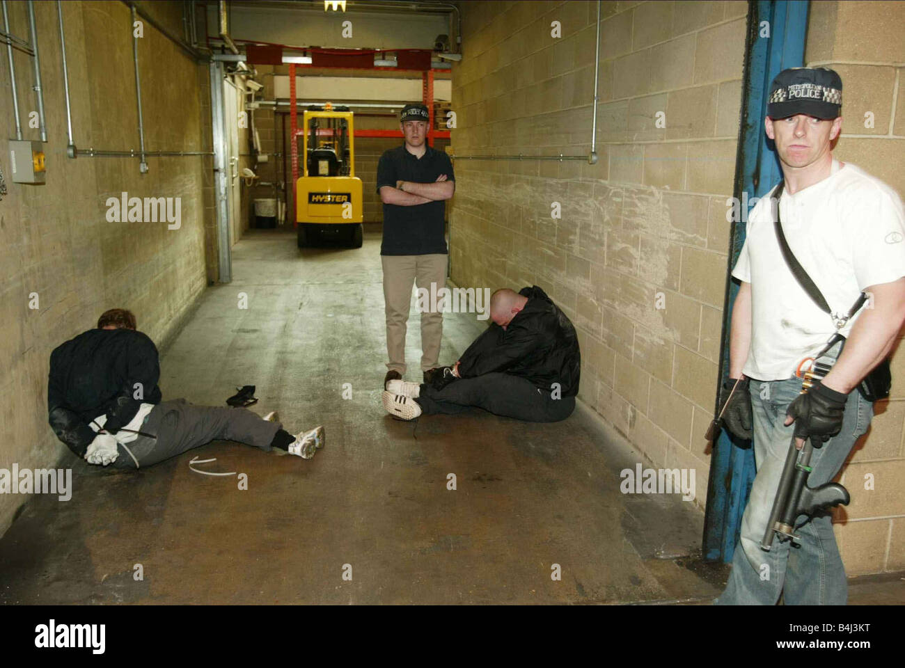 Poliziotti armati e rapina sospetti sulla scena di un tentativo di 30 milioni di euro pound bullion raid in Swissport vicino all' Aeroporto di Heathrow Giugno 2005 sventato Gold bullion rapina a Heathrow 2000sBULLION RAID IN SWISSPORT HEATHROW predatori di essere arrestato dalla polizia armata Giugno 2005 sventato Gold bullion rapina a Heathrow 2000s mirrorpix Foto Stock