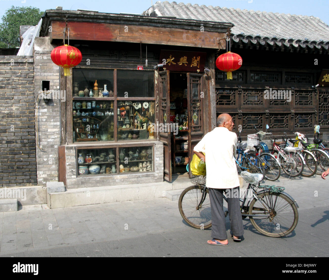 Il vecchio uomo con la bici in sbieco il tabacco Pouch Street Hutong a Yandai byway, Jin Dynasty Yinding bridge, Shichahai District, Pechino Foto Stock