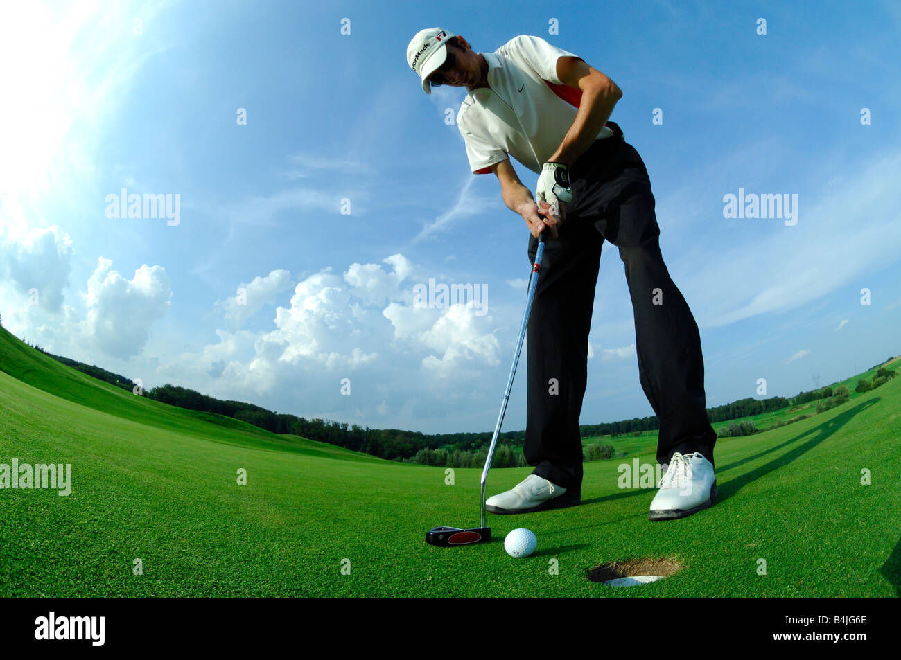 Un ampio e basso view golf giocatore guida un messo vicino al foro sul verde del campo da golf - Francia Foto Stock